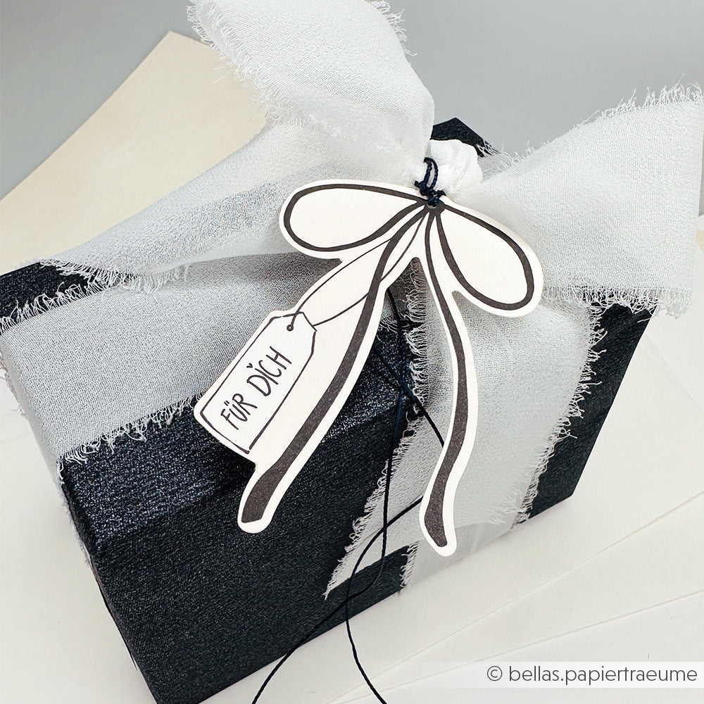 Schwarze Geschenkbox von Alexandra Renke mit weißer Schleife und einem "Für Dich"-Anhänger - ideal für Papertie Projekte oder um charmante Ephemera und Papierelemente zu Ihrem besonderen Geschenk hinzuzufügen.
