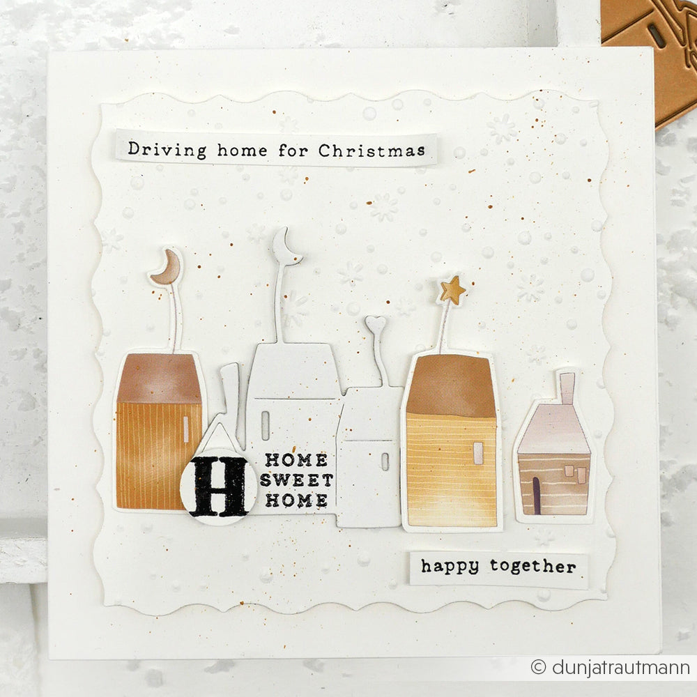 Handgefertigte Karte von Alexandra Renke mit fünf stilisierten Häusern, dem Text "HOME SWEET HOME" und "Driving home for Christmas and happy together" - ein besonderes festliches Andenken.