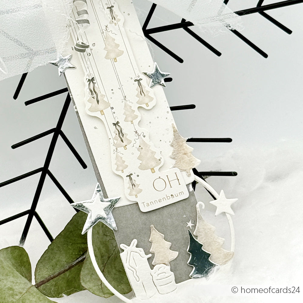Handgefertigte Weihnachtskarte von Alexandra Renke mit hängenden Papierbäumen, silbernen Sternen, Geschenken und dem Text "OH Tannenbaum" - ideal für Papertie-Projekte oder zur Ergänzung Ihrer festlichen Ephemera-Sammlung mit einzigartigen Papierelementen.