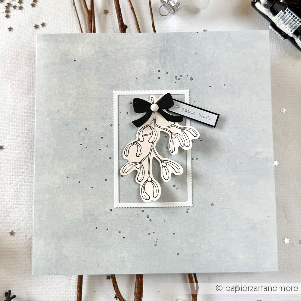 Handgefertigte Alexandra Renke-Karte mit schwarz-weißer Mistel-Illustration, schwarzer Schleife und FROHE WEIHNACHTEN-Anhänger - ideal für Papertie-Projekte oder festliche Ephemera.