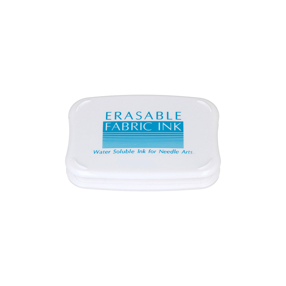 Weißer Tsukineko Erasable Fabric Ink Behälter mit blauer Tinte, wasserlöslich für Stickarbeiten oder als Stempelkissen abwaschbar, abgebildet auf einem weißen Hintergrund.