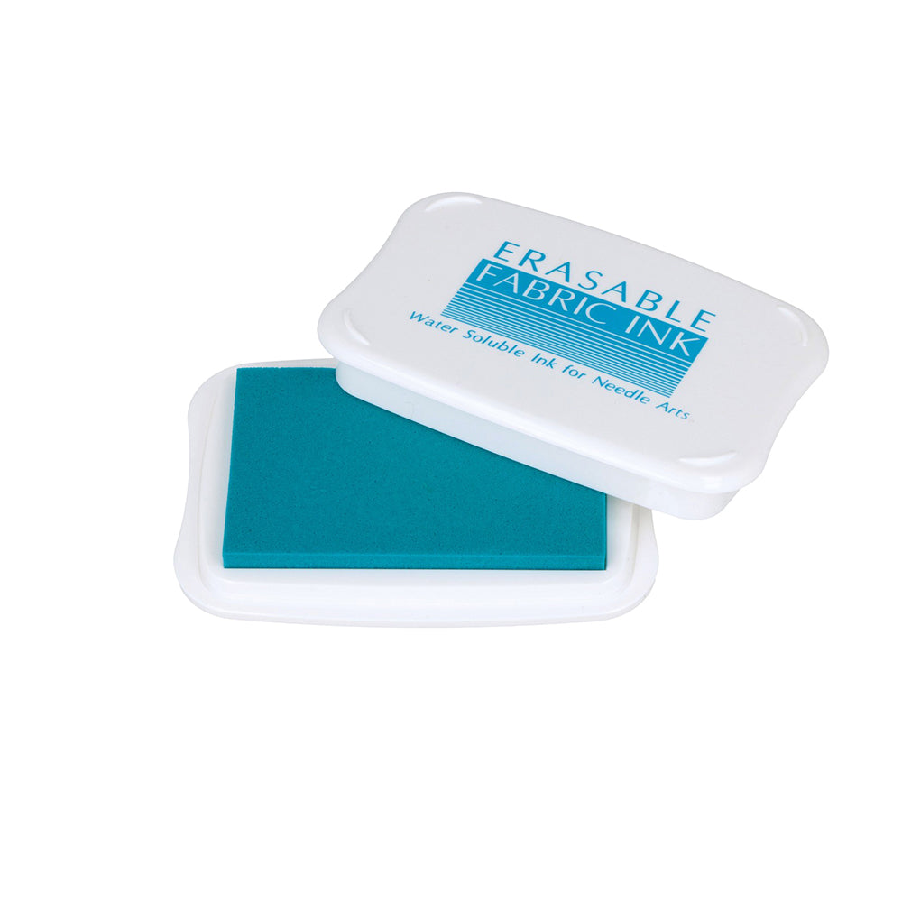 Öffnen Sie den weißen Behälter mit der Aufschrift Tsukineko Erasable Fabric Ink und Sie erhalten ein blaues Stempelkissen, das sich perfekt für Stickarbeiten eignet. Die abwaschbare blaue Tinte ermöglicht ein einfaches Markieren und Löschen von Stoffen, was sie zu einem idealen Stempelkissen für Stoffbasteleien macht.