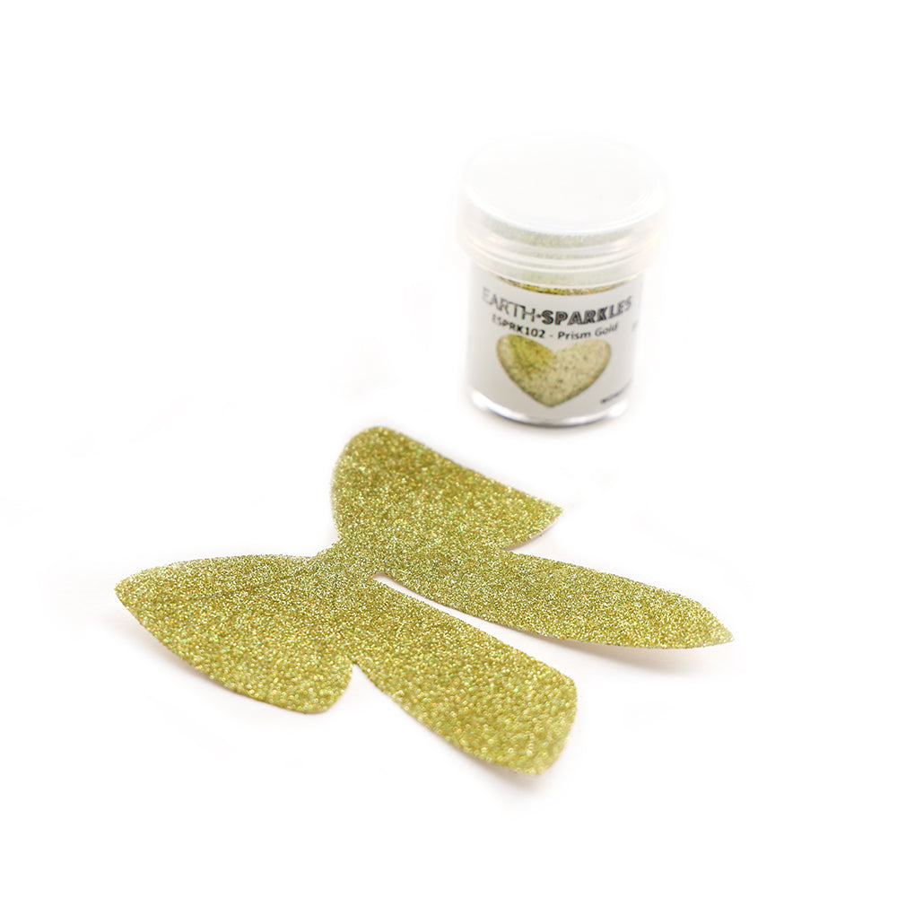 Eine kleine Dose WOW Embossing Powder Bio Glitter steht neben Schmetterlingsflügeln mit Goldglitter auf weißem Hintergrund.