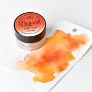Eine Dose Lindy's Stamp Gang hochpigmentiertes Magic Powder in Hags Wart Orange steht neben einem Aquarellmuster auf weißem Papier, ideal für Farbmischungen und einzigartige kreative Effekte.