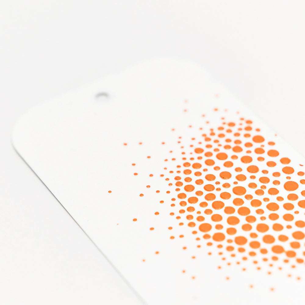 Weiße Karte mit orangefarbenen Punkten, die am Rand verblassen, hergestellt mit der Schablonenbutter von The Crafters Workshop für einen glatten, lebendigen Mixed-Media-Effekt auf weißem Hintergrund.