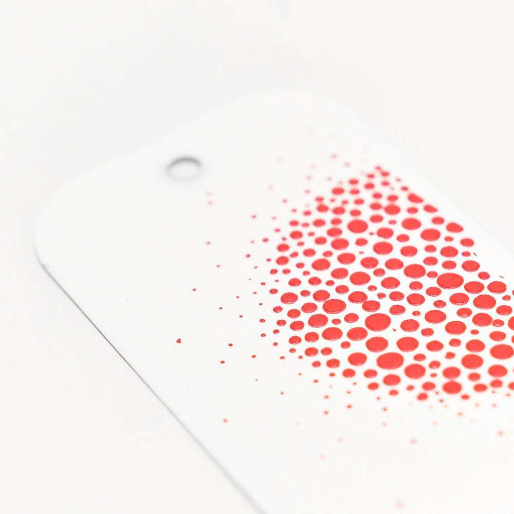 Die Schablone von Crafters Workshop besteht aus einer weißen Karte mit einem Loch und roten Punkten in verschiedenen Größen - ideal, um mit Stencil Butter Texturen hinzuzufügen oder in Mixed Media Projekten zu verwenden.