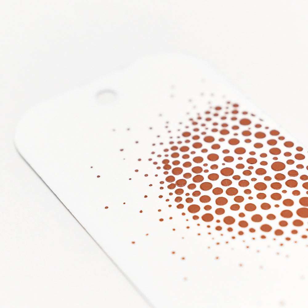 Weiße Karte mit abgerundeten Ecken und kupferfarbenen Punkten, die auf einer Seite mit der Schablonenbutter von The Crafters Workshop für einen reichhaltigen, strukturierten Mixed-Media-Effekt angeordnet sind.