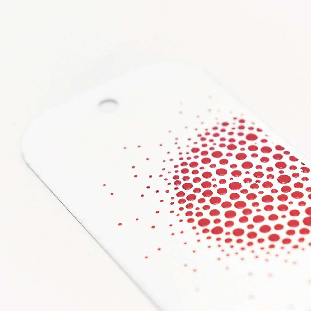 Der weiße Anhänger von Crafters Workshop hat ein rotes Rasterpunktmuster und ein Loch oben links - perfekt für Mixed-Media-Projekte mit Stencil Butter oder Modellierpaste.