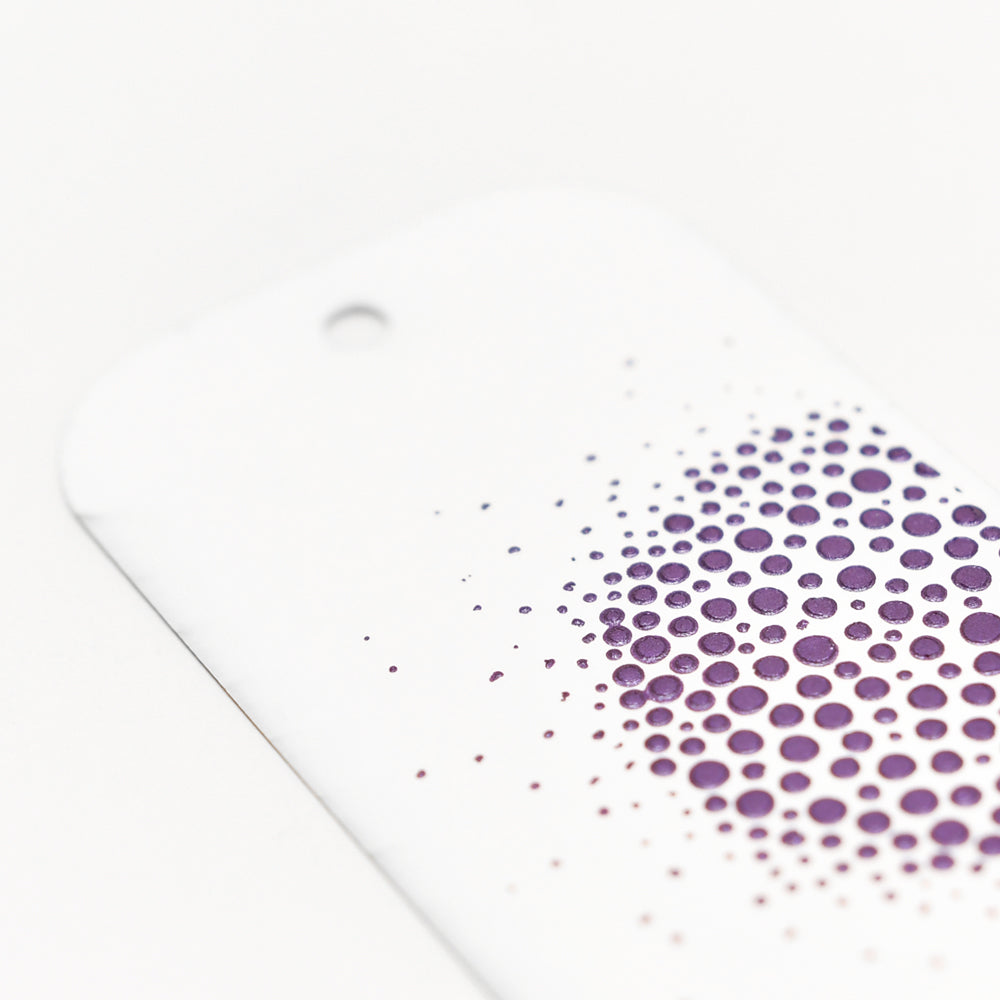 Die weiße Karte von Crafters Workshop mit einem Loch oben und einem lilafarbenen Punktverlauf unten rechts - ideal zum Hinzufügen von Modellierpaste oder Stencil Butter, um Ihr nächstes Mixed-Media-Projekt zu verschönern.