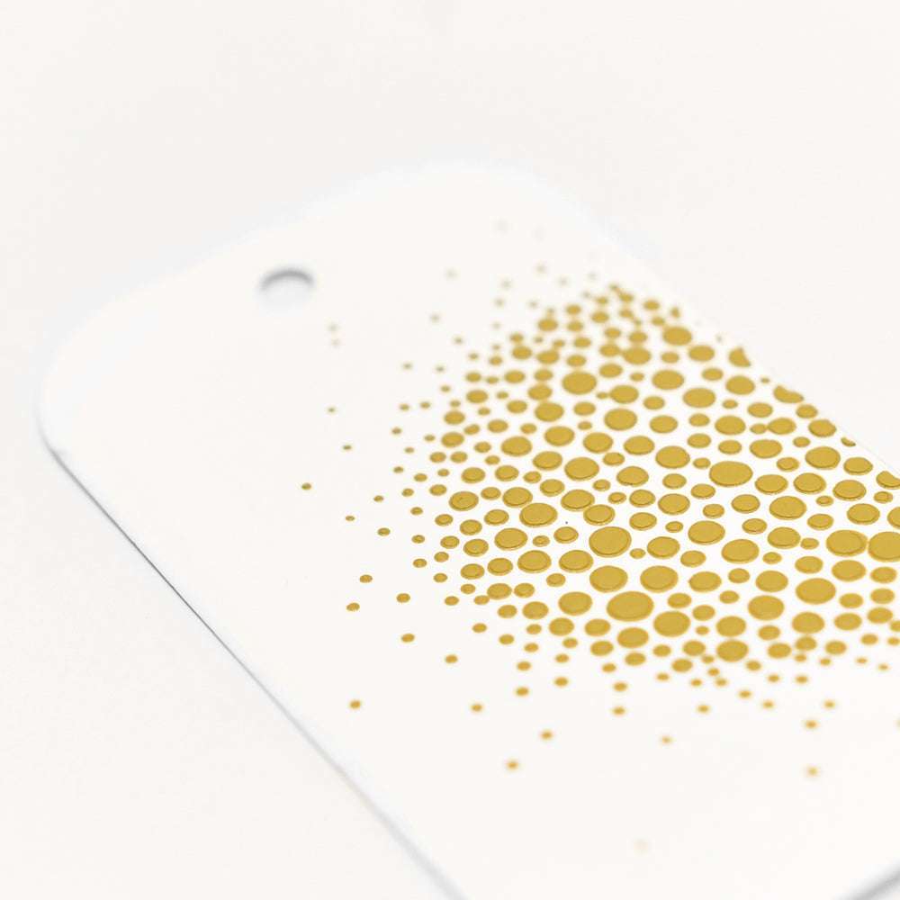 Der weiße Geschenkanhänger von Crafters Workshop ist mit goldenen Punkten unterschiedlicher Größe versehen, die sich dicht aneinanderreihen und zu einer Seite hin auslaufen - ideal, um Ihren Projekten einen Mixed-Media-Touch zu verleihen.