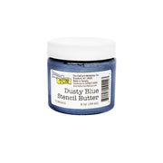 Ein 2 oz. (59 ml) Glas „Dusty Blue Stencil Butter“ von The Crafter's Workshop mit weißem Deckel und Etikett eignet sich perfekt für Mixed-Media-Projekte. Diese Modellierpaste mit reichhaltiger Textur verleiht Ihren kreativen Kunstwerken wunderschöne Tiefe und einen zarten Schimmer.
