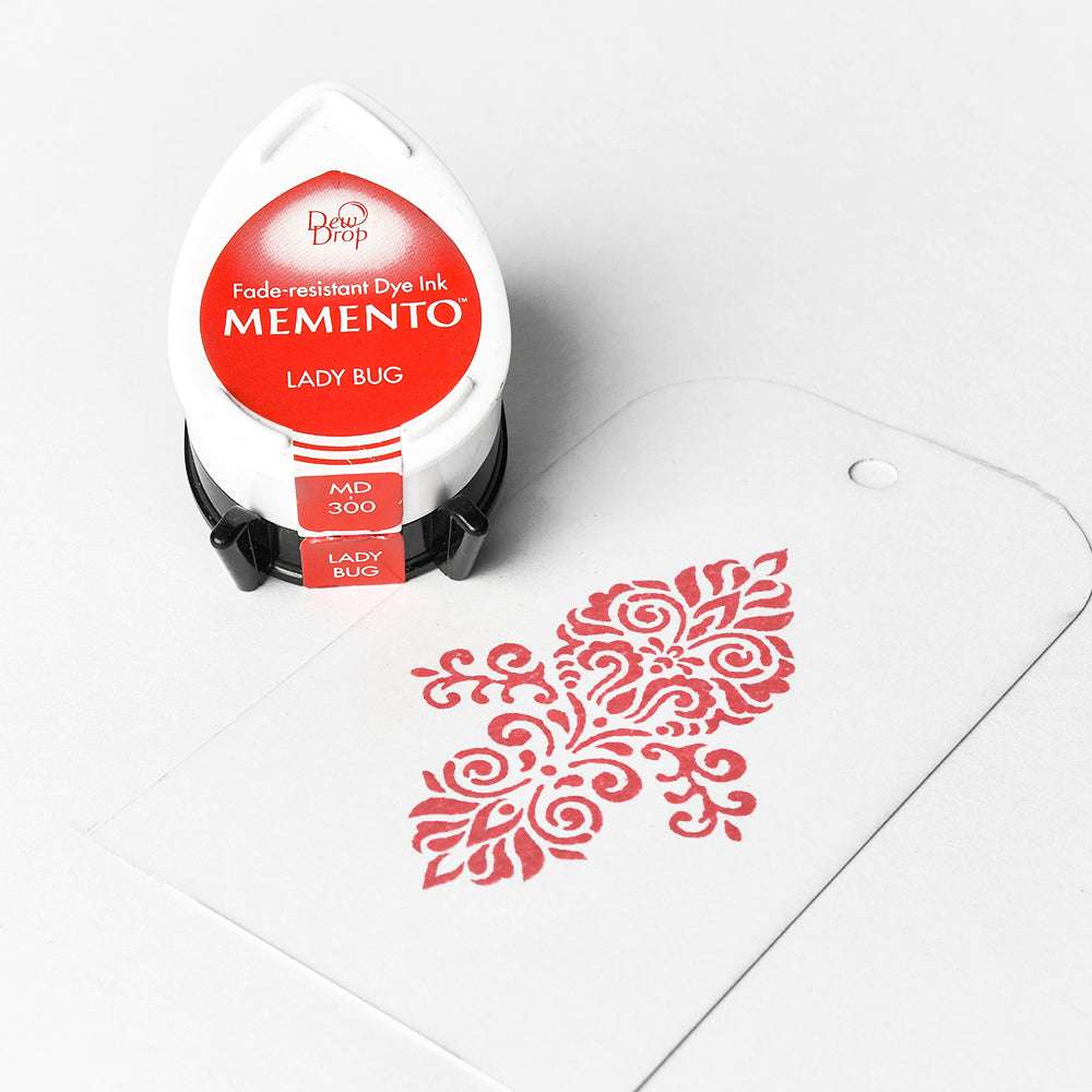 Tsukineko Stempelkissen in Rot mit hochpigmentierter Farbe und einem weißen Anhänger, verziert mit rotem Stempelmotiv auf weißem Hintergrund.