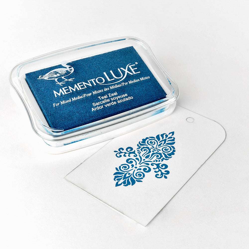 Blaues Stempelkissen von Tsukineko mit Pigmenttinte, das ein verziertes blaues Blumenmotiv auf einem weißen Anhänger zeigt.