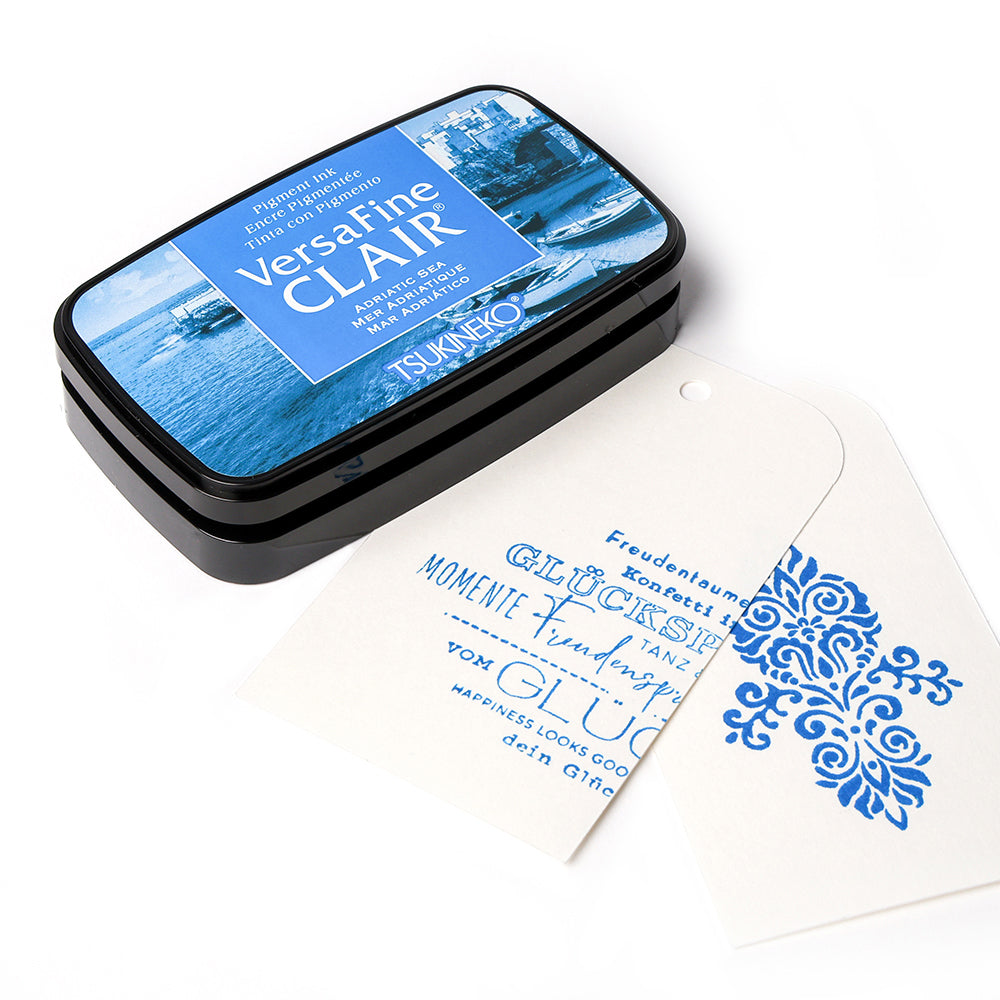 Ein Tsukineko VersaFine Clair blau Pigment-Tinte Stempelkissen mit zwei weißen Anhängern in blau-perfekt zum Stempeln feiner Details gestempelt.