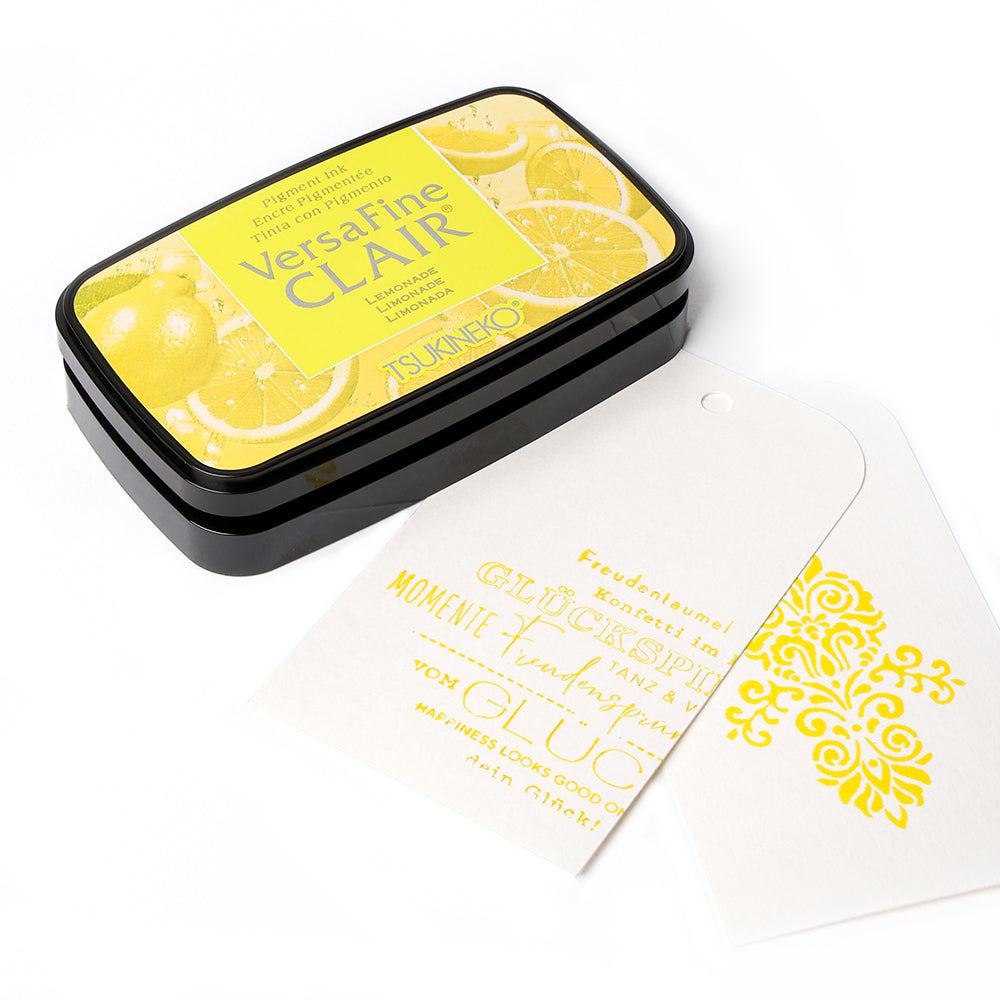 Tsukineko VersaFine Clair Pigment-Tinte Stempelkissen in Gelb mit gestempeltem weißen Tag und gelbem Text/Design-ideal für feine Detail-Stempelarbeiten.