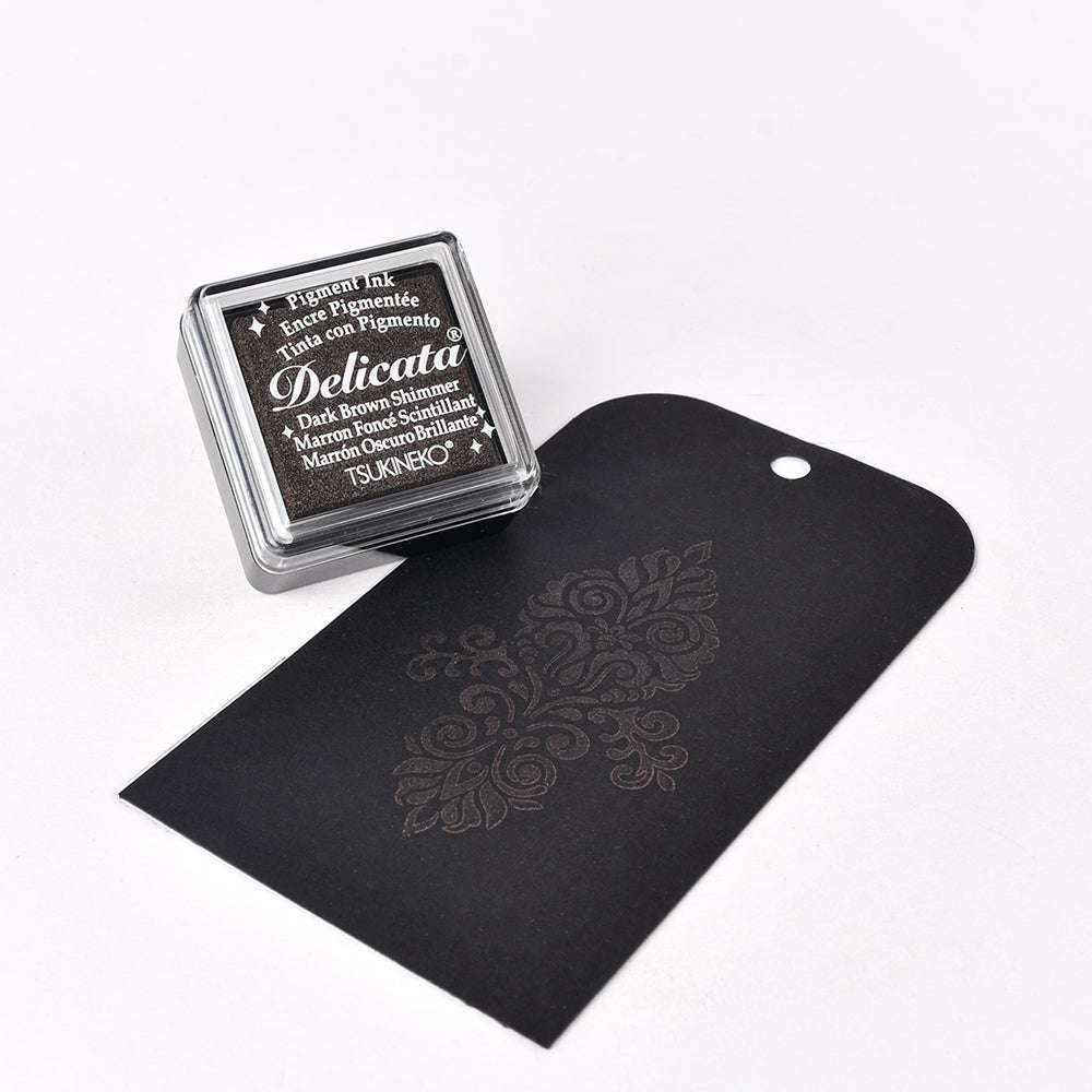 Ein Tsukineko Delicata Mini Stempelkissen in Schwarz und einem floralen Muster - ideal, um Ihren Projekten elegante metallische Effekte zu verleihen.
