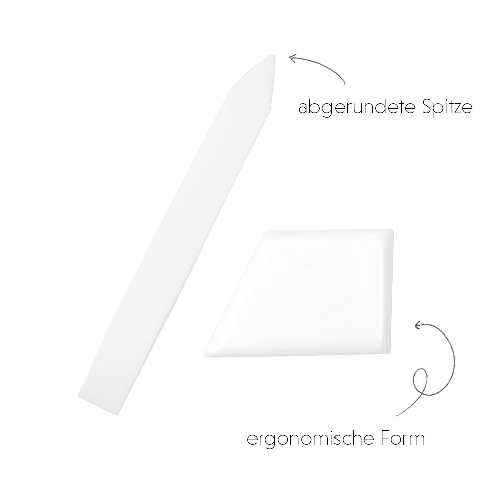 Zwei weiße Alexandra Renke Teflon-Kunststoff-Werkzeuge - ein spitzes und ein flaches - sind ergonomisch gestaltet und in Deutsch für Buchbinden beschriftet.