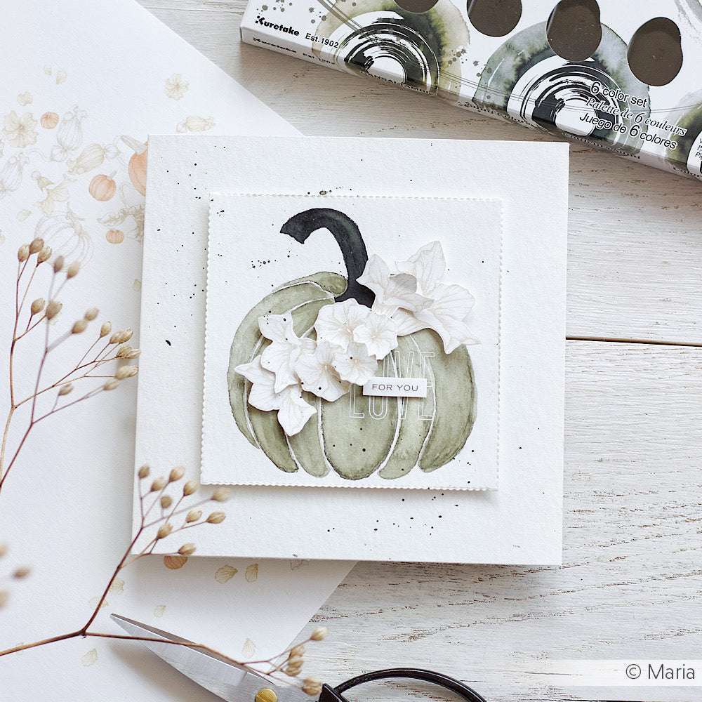 Handgefertigte Karte mit einem mit Kuretake Gansai Tambi Sumi-Farben gemalten Aquarellkürbis, akzentuiert durch weiße Blumen und eine FOR YOU-Nachricht, auf einer weißen Holzoberfläche.
