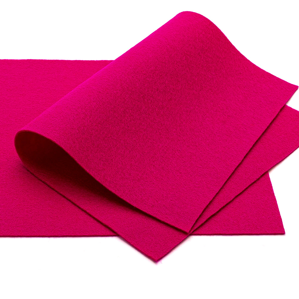 Zwei Blätter leuchtend pinkfarbener ☆ Filz, von denen eines teilweise über das andere gefaltet ist, auf weißem Hintergrund.