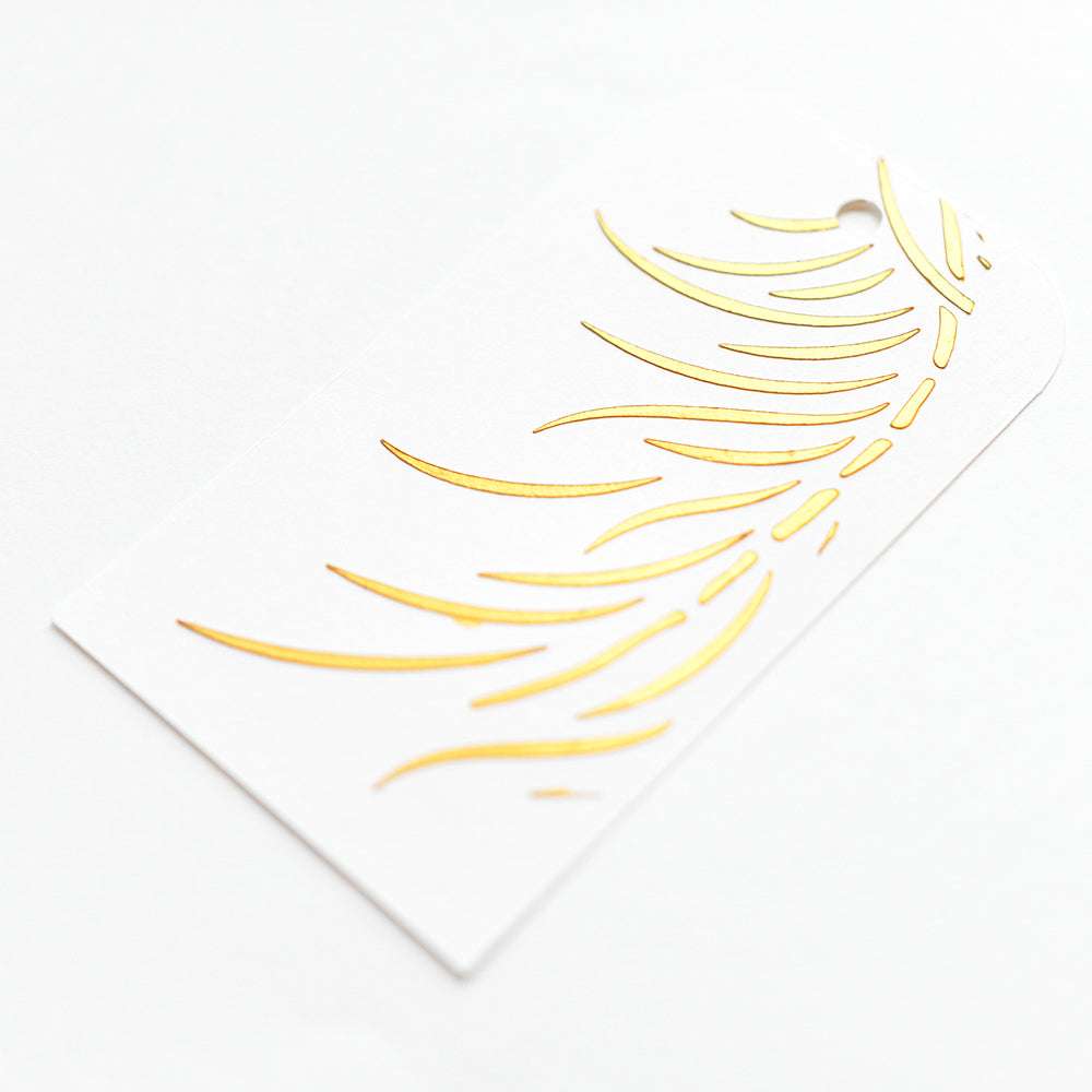 Weißer Geschenkanhänger von Alexandra Renke mit einem abstrakten Blatt- oder Federmotiv in Gold - perfekt für Papierprojekte oder in Kombination mit wiederverwendbaren Schablonen für kreatives Flair.
