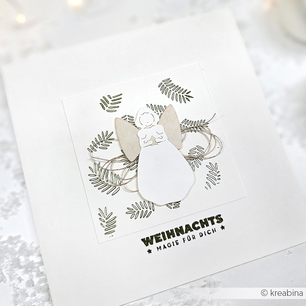 Handgefertigte Weihnachtskarte von Alexandra Renke mit einem Papierengel und Tannenzweige-Muster, mit dem Text "WEIHNACHTS MAGIE FÜR DICH.