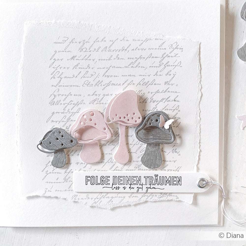 Papier von Alexandra Renke mit rosa und grauen Pilzen, handgeschriebener Schrift und einem FOLGE DEINEN TRÄUMEN-Anhänger, hergestellt mit Motivstanze Artist Pilz Stanzformen und Stanzsystemen für präzise Details.