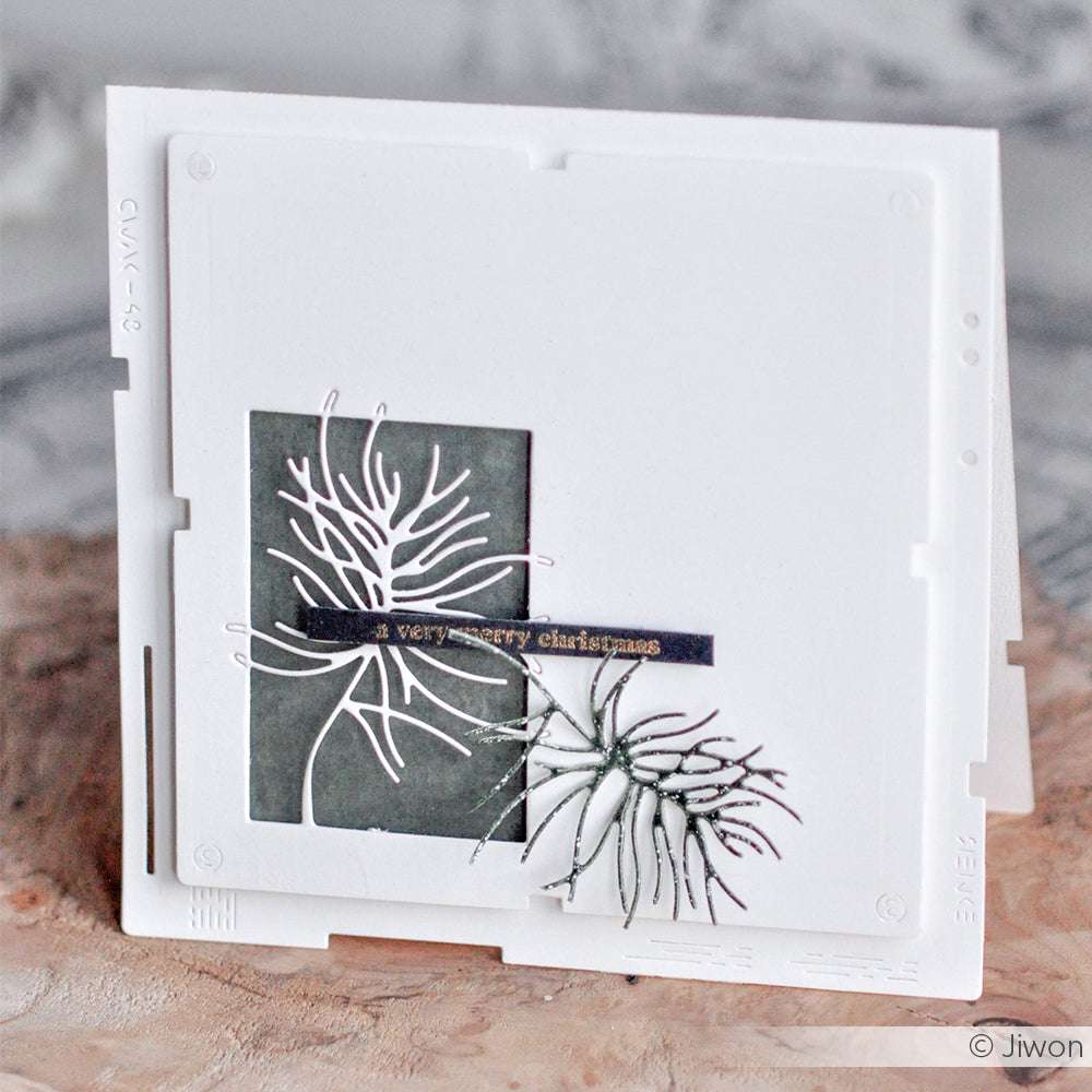 Handgefertigte weiße Weihnachtskarte von Alexandra Renke mit abstraktem silbernem Blattwerk von Stanzen für Papier und einem "very merry christmas"-Gruß auf einem dunklen Rechteck.