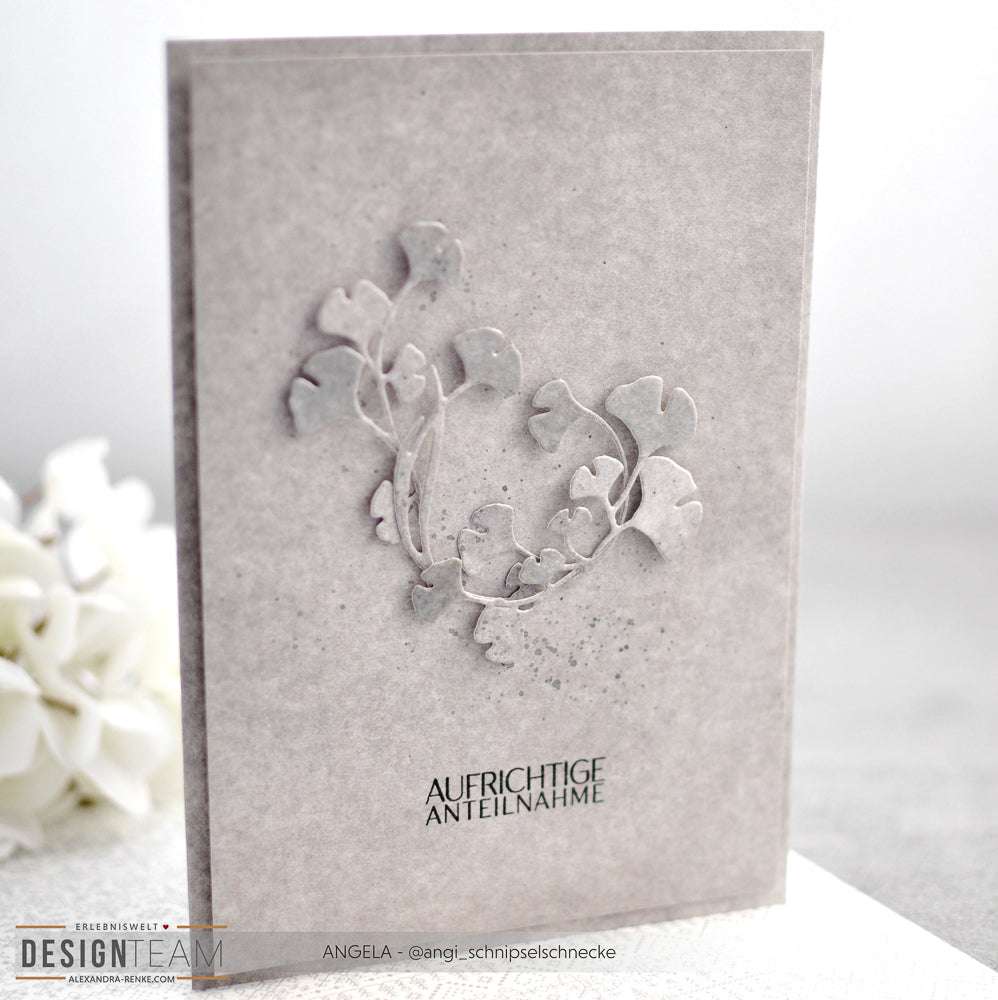 Graue Beileidskarte von Alexandra Renke aus elegantem Designpapier mit geprägtem Blattmotiv und dem deutschen Text "AUFRICHTIGE ANTEILNAHME" auf der Vorderseite.