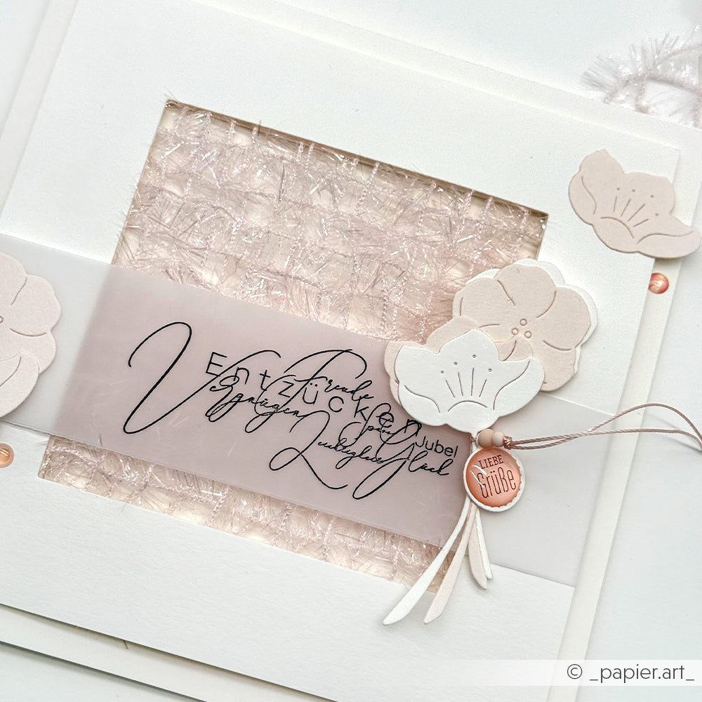 Handgefertigte Karte mit zarten Papierblumen, die mit Alexandra Renke Designpapieren und der Motivstanze Quittenblüten hergestellt wurden, veredelt mit einem rosafarbenen Wachssiegel und eleganter Kalligraphie auf einem durchscheinenden Band.