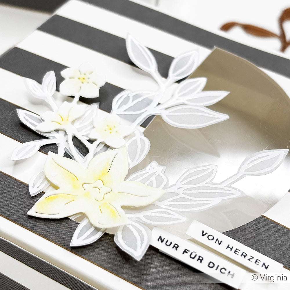 Eine gestreifte Geschenkschachtel, verziert mit weißem und gelbem, floralem Alexandra Renke Motivstanze Vanilleblüten Designpapier, verziert mit einem Anhänger mit der Aufschrift "VON HERZEN NUR FÜR DICH".