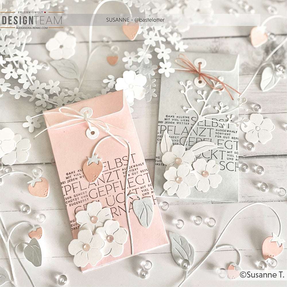 Zwei verzierte Geschenkumschläge mit weißen Blumenausschnitten, Herzen und zarten Verzierungen auf hellem Grund, hergestellt mit dem Alexandra Renke Motivstanze Erdbeerblüten Set für filigrane Details.