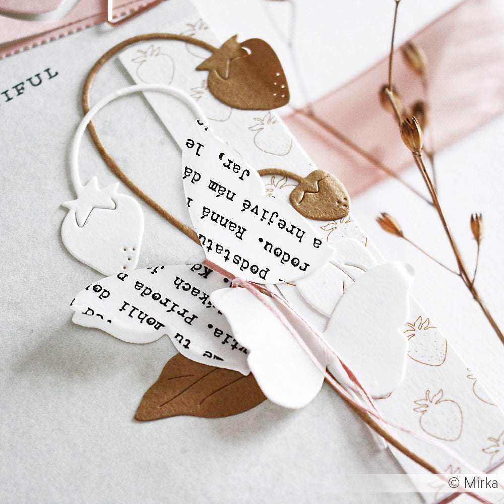 Papiererdbeeren in Weiß, Gold und Textdruck von Alexandra Renke werden auf einer Karte geschichtet und mit Bindfaden und getrockneten Pflanzenstängeln akzentuiert.