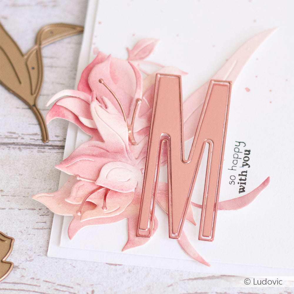 Pinkfarbene Blumenkarte von Alexandra Renke mit einem großen Metallic-"M", gestaltet mit Motivstanze Die Schichtblume 4 auf hochwertigem Designpapier, und dem Teiltext "so happy with you" auf weißem Hintergrund.
