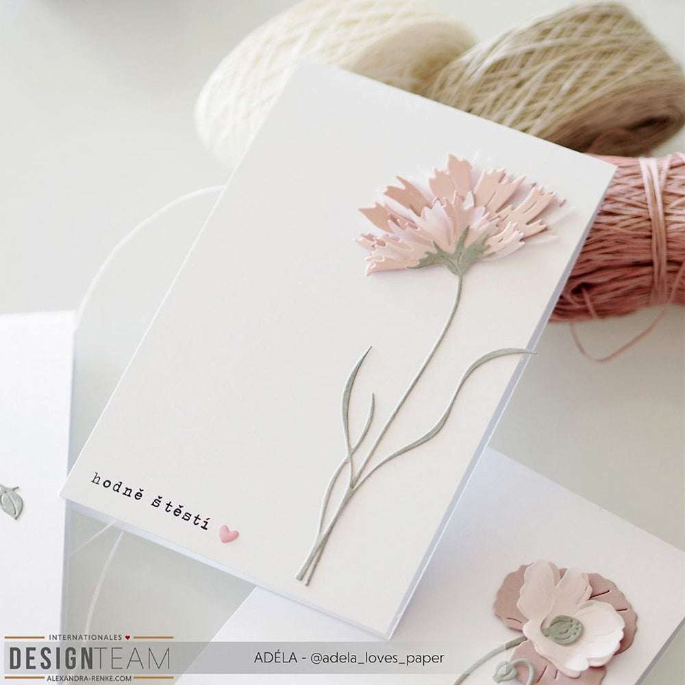 Eine handgefertigte Karte von Alexandra Renke mit einer Schichtblume 5 aus rosa Papier, hergestellt mit Stanzsystemen, und dem tschechischen Text "hodně štěstí" neben einem kleinen rosa Herz.