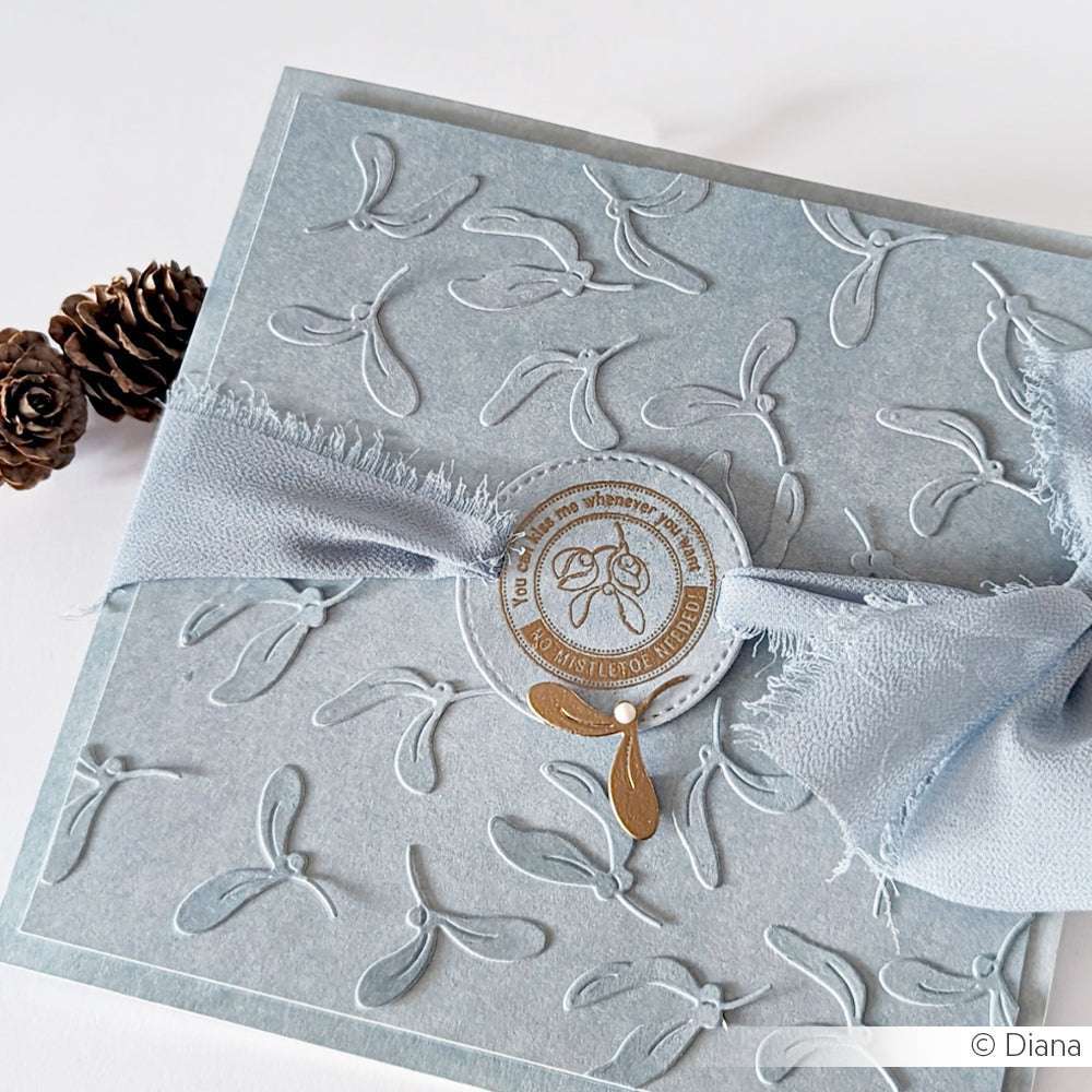 Elegante blaue Geschenkschachtel mit geprägtem Blattmuster aus dem Mini Blätter Set Motivstanze von Alexandra Renke, veredelt mit einem Stoffband und einem runden Siegel - ein schönes Präsent für Stanzsysteme-Liebhaber.