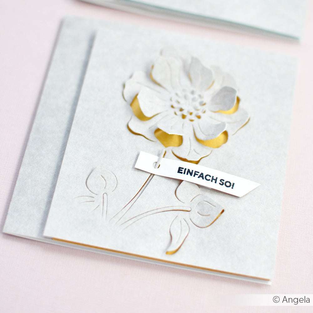 Weiße Grußkarte von Alexandra Renke mit einer Motivstanze Negativ-Blume 4 zum Ausschneiden und einem Schild mit der Aufschrift "EINFACH SO!", das am Stiel befestigt ist.