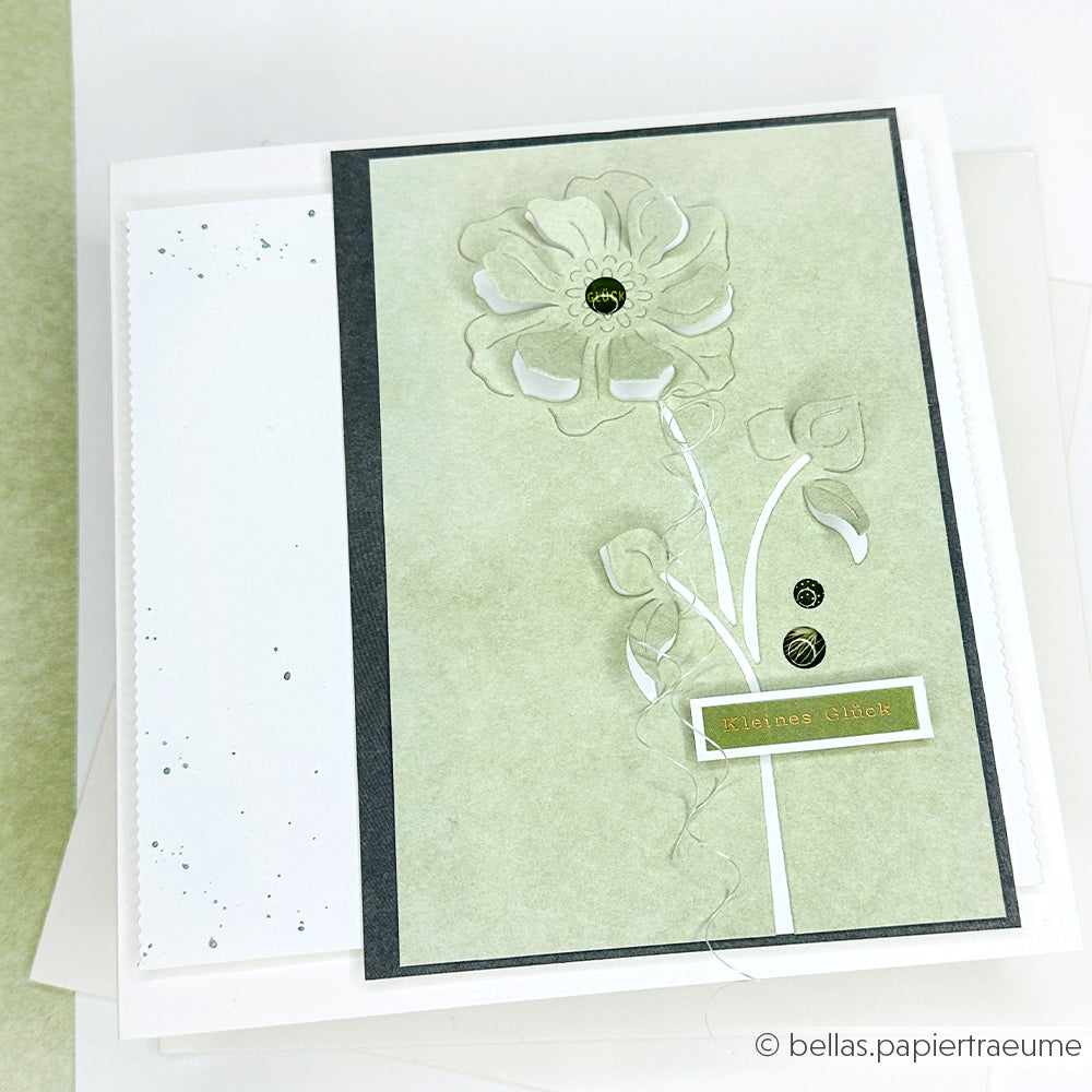 Handgefertigte Karte von Alexandra Renke mit einer großen geprägten Blume mit Designpapieren und Motivstanze Negativ-Blume 4 DieCut System, mit dem Text "Kleines Glück" auf hellgrünem und weißem Hintergrund.