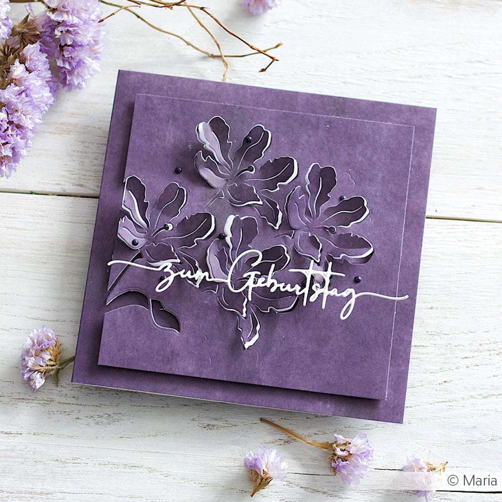 Lila blumige Geburtstagskarte von Alexandra Renke mit ausgeschnittenen Blumen mit Motivstanze und DieCut Systemen, Text "Zum Geburtstag" und kleinen lila Blumenakzenten.