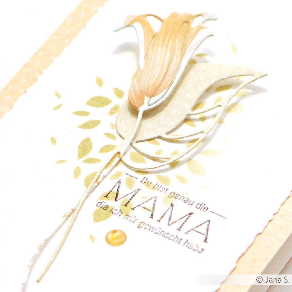 Eine Papierblume mit Blättern, hergestellt mit Alexandra Renke Designpapieren und Motivstanze Große Kelchblüten DieCut Systeme, wird auf einer cremefarbenen Karte mit dekorativem deutschen Text gezeigt.