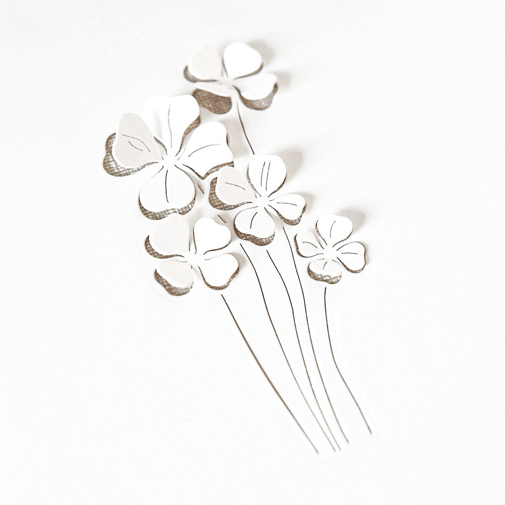 Zarte weiße Papierblumen von Alexandra Renke, hergestellt mit DieCut Systemen und Designpapieren. Mit dünnen Stielen auf weißem Hintergrund für einen minimalistischen, eleganten Look.
