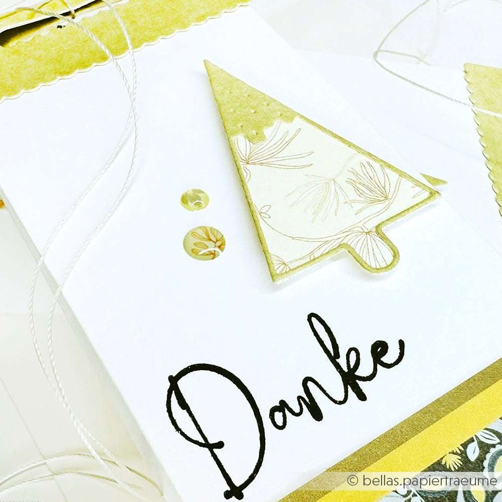 Weiße Karte von Alexandra Renke mit einem goldenen Baum aus der Motivstanze Tanne, verziert mit Pailletten und "Danke" in Schreibschrift am unteren Rand.