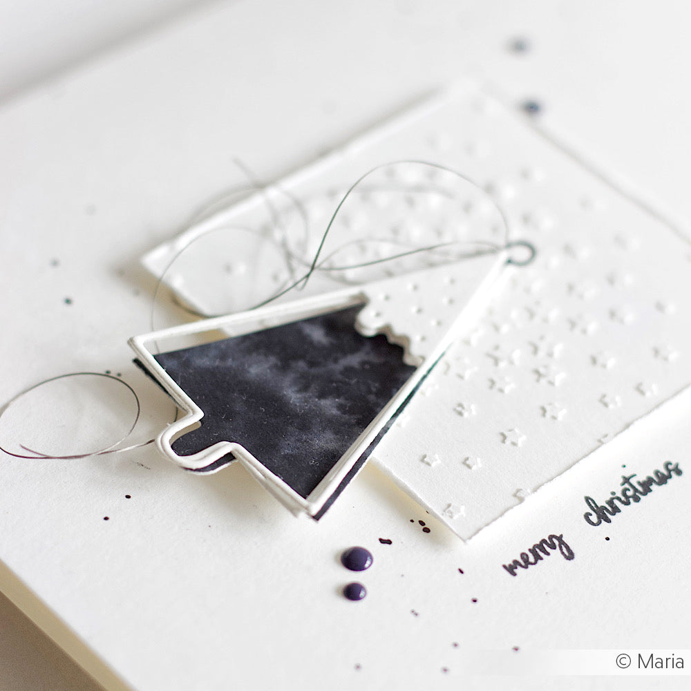 Minimalistische Weihnachtskarte von Alexandra Renke mit schwarz-weißem Baumschmuck aus der Motivstanze Tanne auf hochwertigen Designpapieren und "Frohe Weihnachten" auf strahlend weißem Hintergrund.