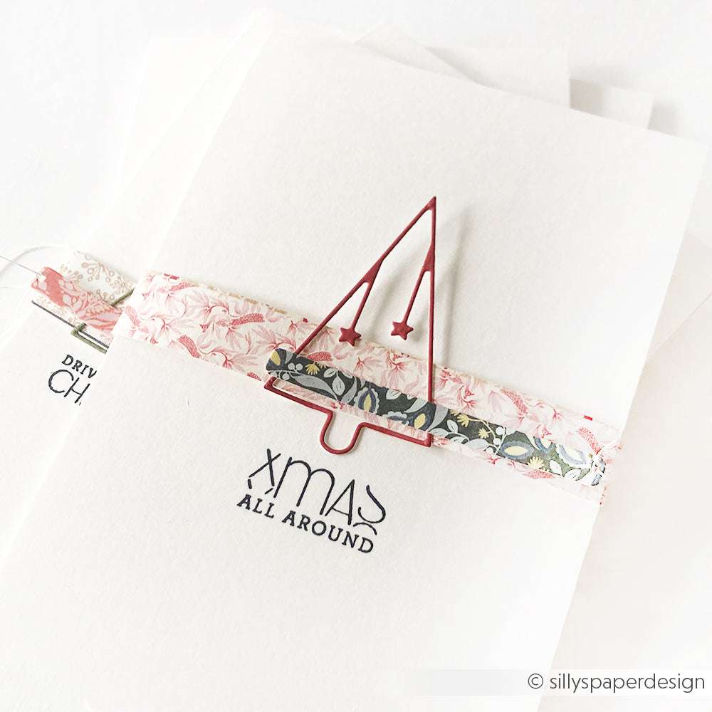 Minimalistische Weihnachtskarte von Alexandra Renke mit einer einfachen Baumkontur, gestaltet mit Motivstanze Tanne und einem floralen Band auf hochwertigen Designpapieren. Der Text lautet "Xmas All Around".