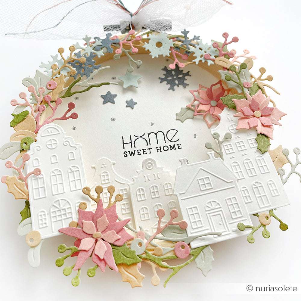 Papierkranz mit Alexandra Renke DieCut Systemen, pastellfarbenen Blüten, Blättern, Schneeflocken und weißen Häusern von Designpapiere. In der Mitte steht "Home Sweet Home" - eine bezaubernde Motivstanze für die Weihnachtszeit.