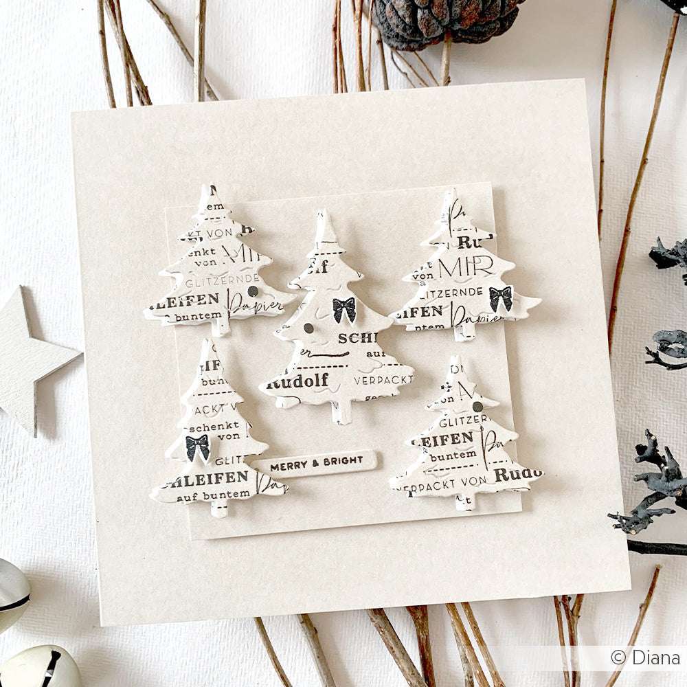Quadratische Weihnachtskarte von Alexandra Renke mit drei weißen Papierbäumen, die mit den Motivstanze Tannen Trio Dies gestaltet wurden, verziert mit schwarzem Text und Schleifen, alles auf einem neutralen Hintergrund aus hochwertigen Designpapieren.