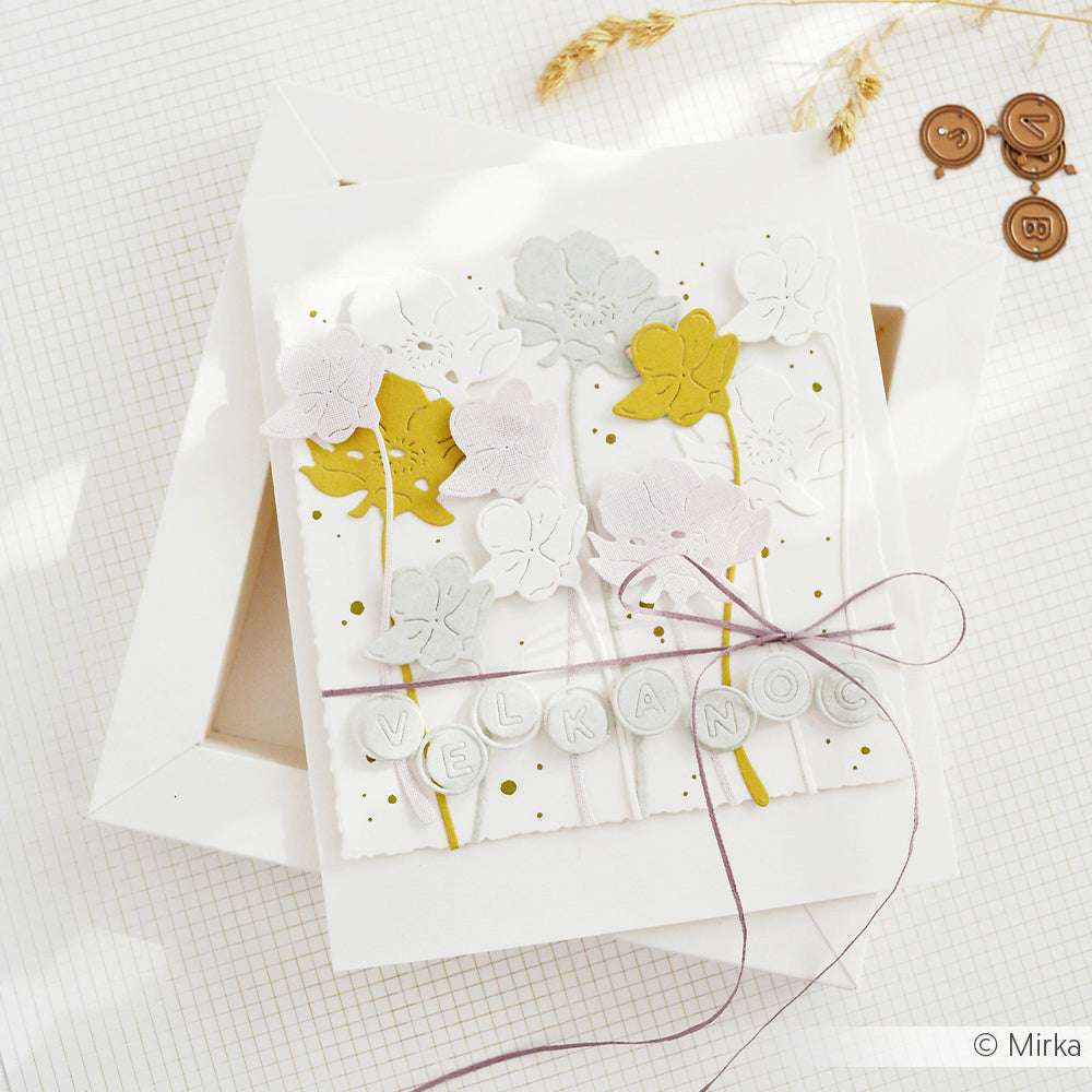 Handgefertigte Blumenkarte von Alexandra Renke mit pastellfarbenen Blumen, gelben Stängeln und dem Schriftzug "VELKONO", gebunden mit lila Kordel, hergestellt mit PAPPcut®ies und Deep Edge Motivstanzen.