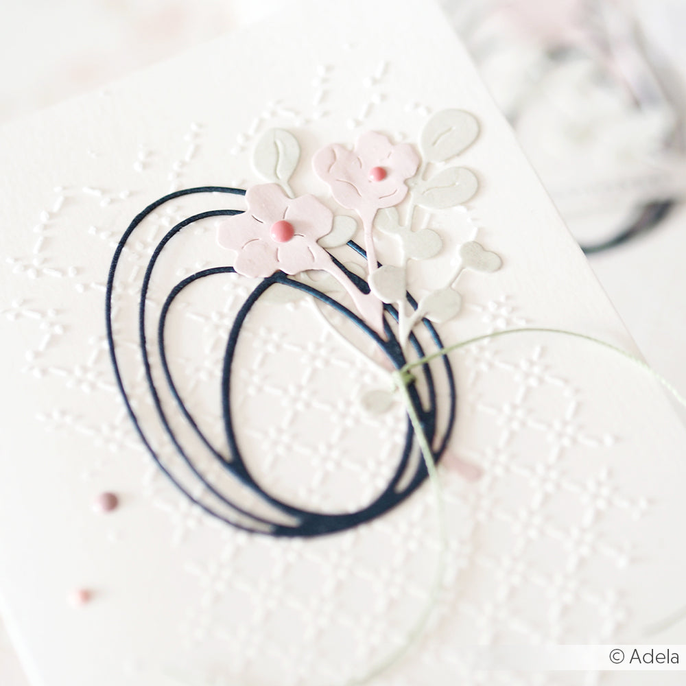 Zarte florale Papierkunst mit der Stanze Alexandra Renke Feines Blüten Duo, mit pastellrosa Blüten auf geprägtem Weiß und einer dunklen ovalen Umrandung - ein echtes Highlight für jede PAPPcut®ies-Kollektion.