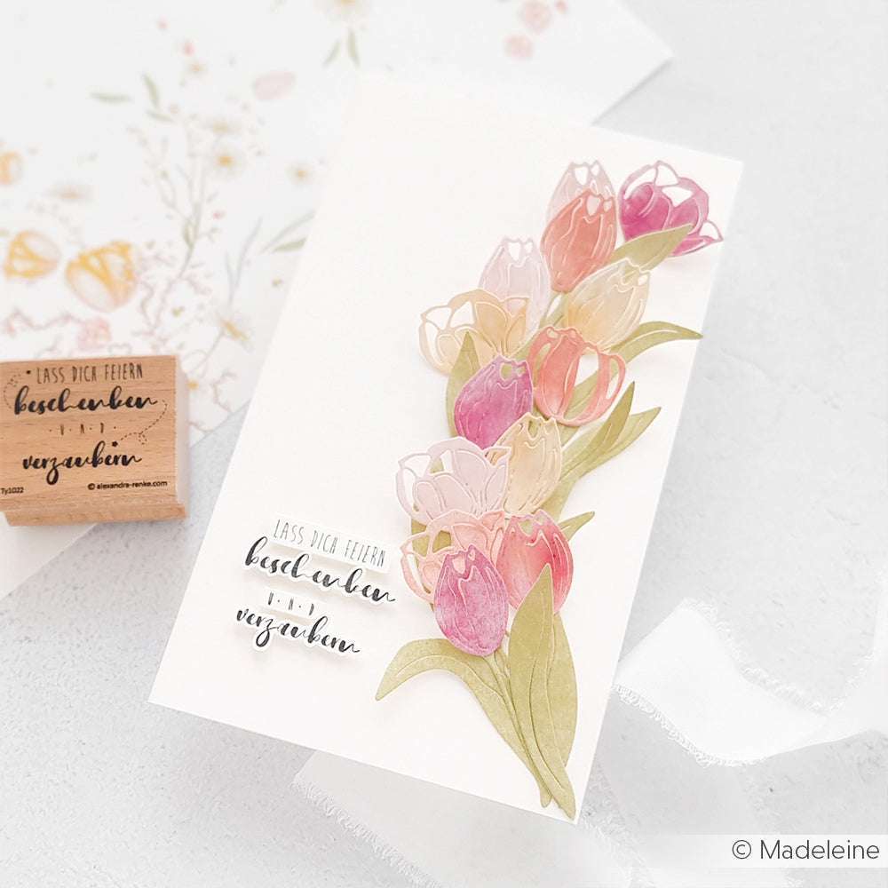 Grußkarte mit geschichteten rosa und lila Tulpen, hergestellt mit Alexandra Renke Motivstanze Tulpe und Deep Edge Stanzen, mit gestempeltem deutschen Text auf der Vorderseite.