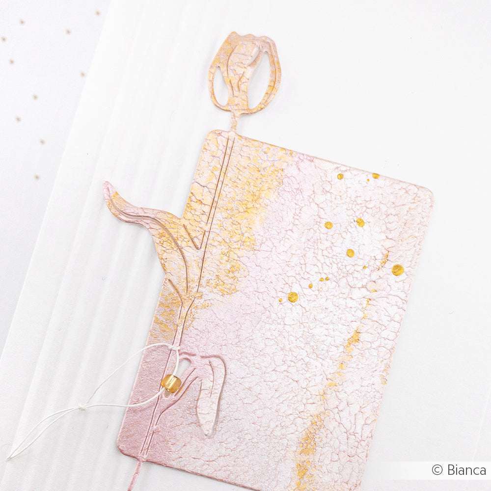 Tulpenförmiges Lesezeichen in Rosa und Gold mit einem strukturierten Muster, inspiriert von Alexandra Renke's Deep Edge Motivstanzen, auf weißem Hintergrund.