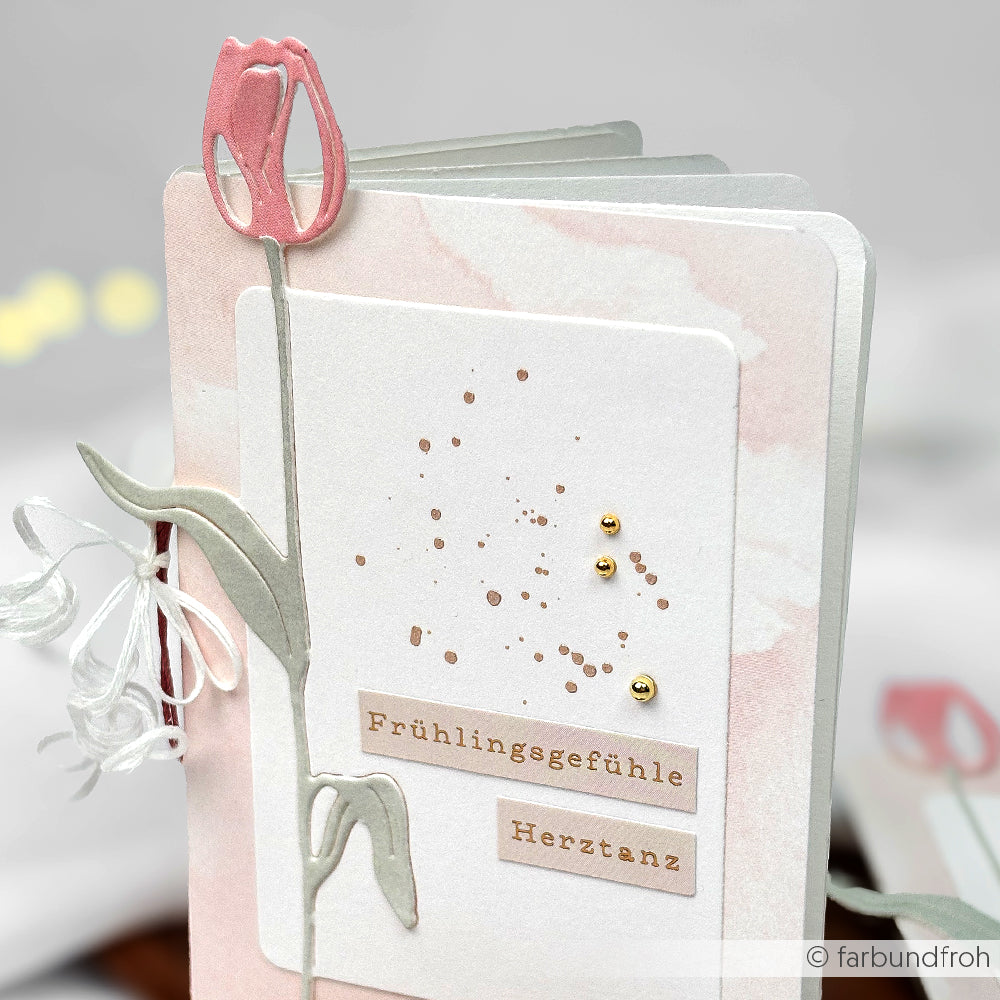 Handgefertigte Alexandra Renke Motivstanze Tulpenkarte mit rosafarbenem Tulpendesign, mit dem Text "Frühlingsgefühle" und "Herztanz" auf marmoriertem Hintergrund. Perfekt für Frühlingsgrüße. Entdecken Sie mehr von PAPPcuties!.